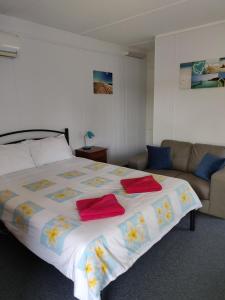 a bedroom with a large bed and a couch at Summers Rest Units in Port Campbell