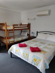 a bedroom with two bunk beds with red pillows on it at Summers Rest Units in Port Campbell
