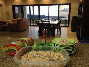 a table with a dish of food on a counter with plates at Playa Limoncito Hills Fraccionamiento Vacacional Villas de 2 & 3 Recamaras con Alberca Privada o Alberca Compartida in Limoncito Hill