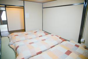 a bed in a room with a quilt on it at Nishioji FUKURO 西大路梟 in Kyoto