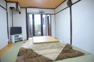 a room with a bed and a flat screen tv at Nishioji FUKURO 西大路梟 in Kyoto