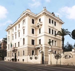 a large white building with a clock on the side of it at Aldrovandi Residence City Suites in Rome
