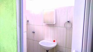 a white bathroom with a sink and a mirror at Quatro Irmãos in Caraguatatuba +59 photos