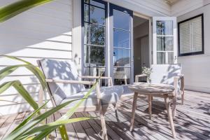 a porch with two chairs and a table and a window at The Martinborough Hotel in Martinborough