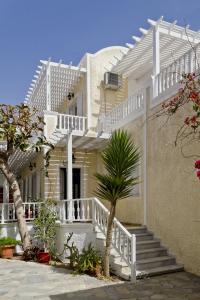 a white house with stairs and a palm tree at Dolphins Apartments in Kamari