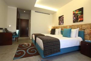 una camera con un grande letto e una scrivania di Monoberge Hotel a Jbeil