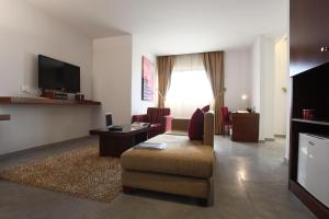 un soggiorno con un divano e una TV di Monoberge Hotel a Jbeil
