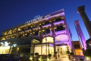 a building with a sign on it at night at Monoberge Hotel in Jbeil