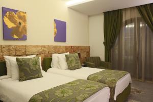 una camera d'albergo con due letti e una finestra di Monoberge Hotel a Jbeil