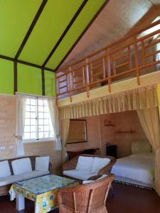 仁愛鄉的住宿－雲上太陽民宿，一间卧室配有一张双层床、一张沙发和一张桌子。