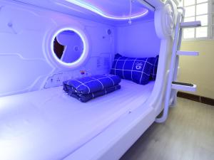 a hospital bed with two blue pillows on it at Spacepod@hive in Singapore