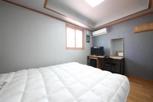 a bedroom with a bed and a desk and a mirror at Gyeongju Bee House in Gyeongju
