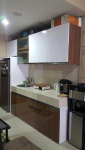 a kitchen with white cabinets and a counter top at The Sixth Room in Yogyakarta