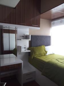 a bedroom with a green bed and a desk at The Sixth Room in Yogyakarta