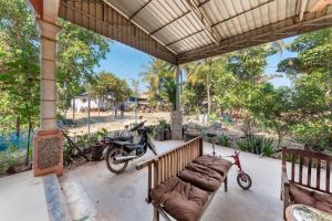 a motorcycle is parked on a porch with a bench at Homestay Chreav in Siem Reap