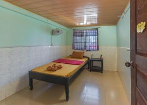 Habitación pequeña con cama y ventana en Homestay Chreav en Siem Riep