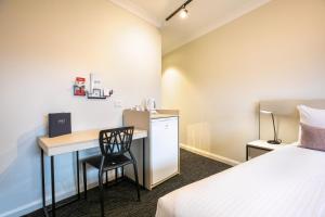 a hotel room with a desk and a bed at Nightcap at Hendon Hotel in Adelaide