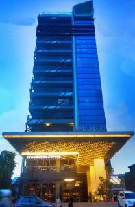 een hoog blauw gebouw met een auto ervoor geparkeerd bij The Sixth Room in Yogyakarta