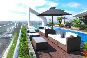 a balcony with chairs and an umbrella on a building at The Sixth Room in Yogyakarta
