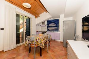 a kitchen with a table with chairs and a refrigerator at Le Tartarughe Aparthotel in Letojanni