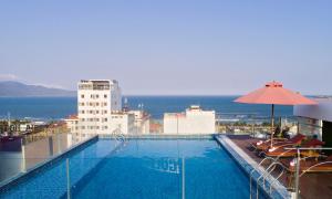 a swimming pool on top of a building with the ocean at Helios Boutique Hotel & Spa in Da Nang