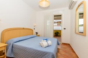 a bedroom with a bed with a towel on it at Le Tartarughe Aparthotel in Letojanni