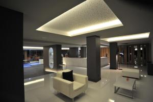 a living room with a white chair and a table at Axis Ofir Beach Resort Hotel in Esposende