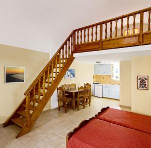 a living room with a staircase and a table and a kitchen at Dolphins Apartments in Kamari