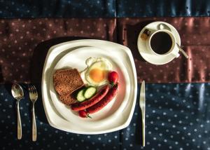 a plate of food with eggs and vegetables and a cup of coffee at Diplomat Noble Hotel in Ulaanbaatar
