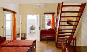 a living room with a staircase and a red couch at Dolphins Apartments in Kamari +36 photos