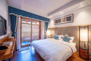 una camera con un grande letto e una finestra di Yuelu Homestay a Zhangjiajie