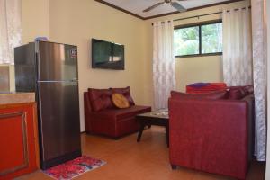 a living room with a refrigerator and two chairs at Siargao Sunset Bay Beach Villas in General Luna