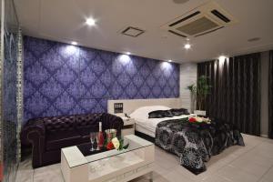 een hotelkamer met een bed en een bank bij Hotel agehA cinq boutique (Adult Only) in Okayama