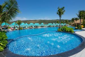 a large pool with chairs and umbrellas at a resort at Phi Phi CoCo Beach Resort in Phi Phi Islands