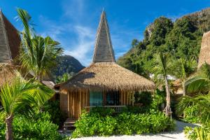 a resort with a thatched roof and palm trees at Phi Phi CoCo Beach Resort in Phi Phi Islands