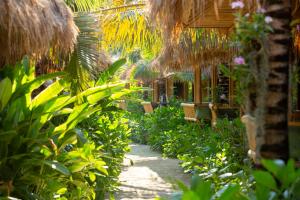 a pathway through a garden with benches and plants at Phi Phi CoCo Beach Resort in Phi Phi Islands