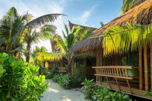 a resort with a bench and some palm trees at Phi Phi CoCo Beach Resort in Phi Phi Islands