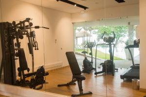 - une salle de sport avec plusieurs tapis de course et un miroir dans l'établissement Montebelo Girassol Maputo Hotel, à Maputo