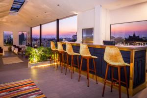 un bar avec des chaises jaunes dans un restaurant avec vue dans l'établissement Lao Poet Hotel, à Vientiane