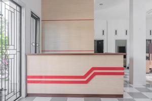 a lobby with a reception desk with red and white stripes at RedDoorz near Sultan Thaha Airport Jambi in Jambi