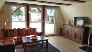 a living room with a couch and a tv at Ferienhaus am Lübbesee in Milmersdorf