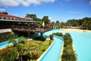 Forest Crest Nature Hotel and Resort Powered by ASTON في ناسوغبو: جسر فوق مسبح في منتجع