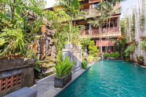 a hotel with a pool in front of a building at Rumah Roda in Ubud