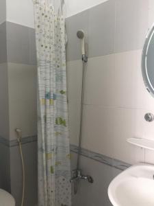 胡志明市的住宿－VY慶旅館，浴室配有淋浴帘和盥洗盆。