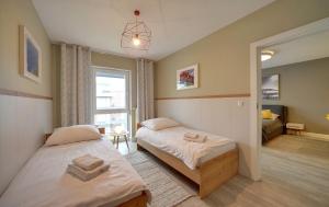 ein Schlafzimmer mit zwei Betten und einem Fenster in der Unterkunft Komfortowe Apartamenty Sun Seasons 24 w Pogorzelicy Blisko Morza by Noclegi Renters in Pogorzelica