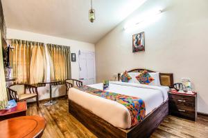 um quarto de hotel com uma cama e uma mesa em FabEscape Saint Clouds em Ooty