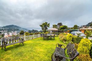 a group of benches sitting in the grass at FabEscape Saint Clouds in Ooty