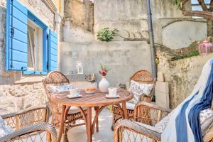 a wooden table and chairs on a patio at ECO Aparthotel The Dreamers's Club in Lumbarda