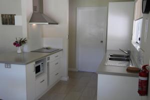 a kitchen with white cabinets and white appliances at Sapphire Chalets, Augusta in Augusta