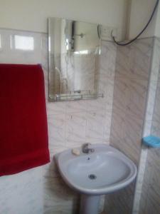 baño con lavabo blanco y toalla roja en Jayanika home stay, en Tangalle